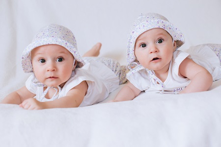 לידת תאומים חמודים בבגדים לבנים